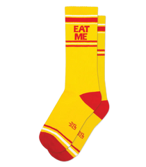 Eat me crew socks in bright yellow with bold red stripes and red eat me text on the cuff with matching toe and heel