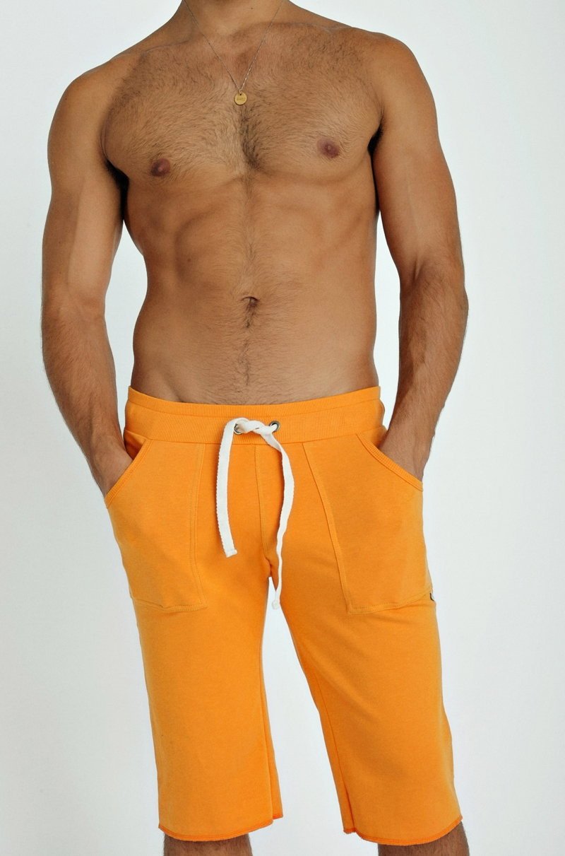 Bright orange eco-track athletic shorts with white drawstring and side pockets designed for active wear