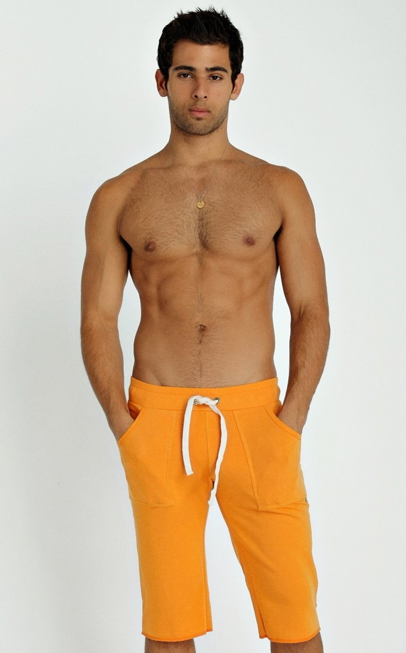 Orange eco-track athletic shorts with white drawstring and side pockets designed for activewear use