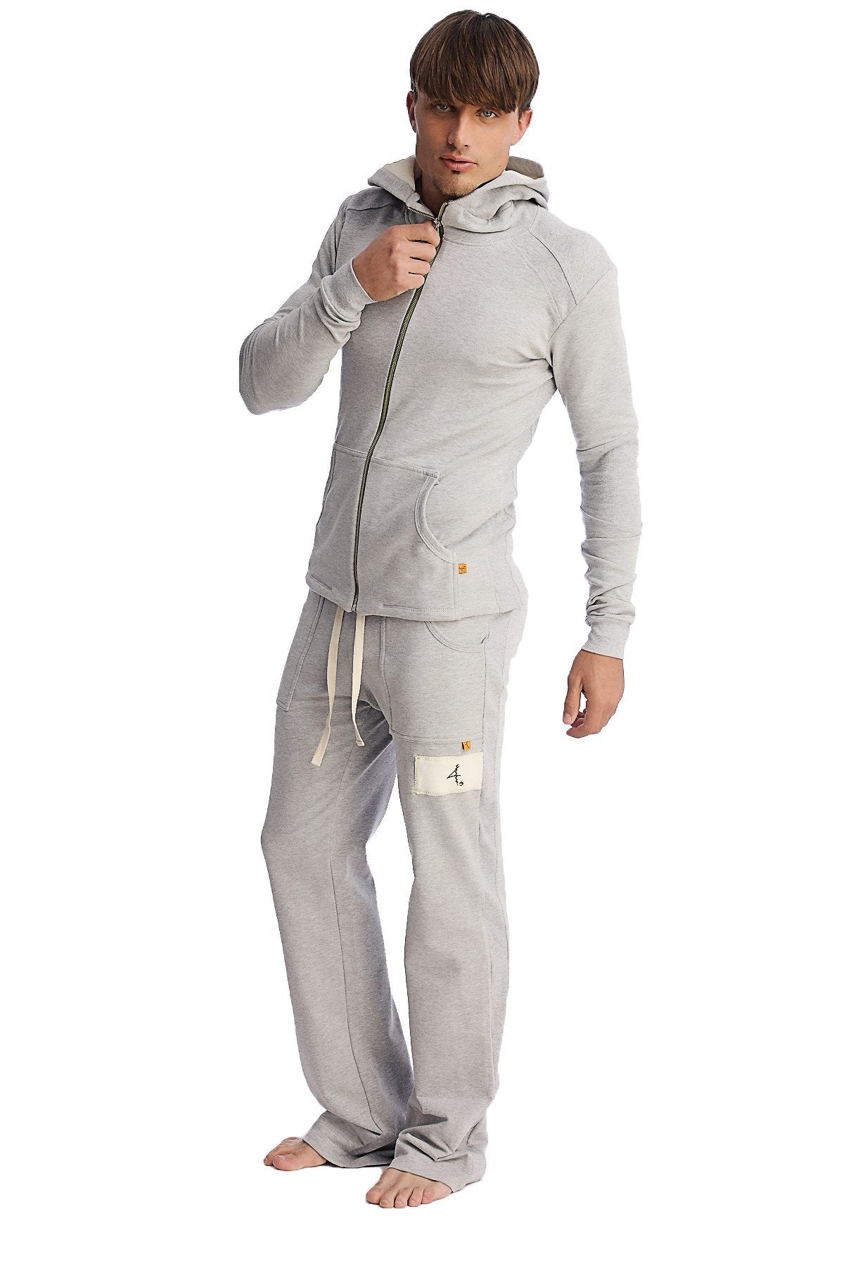 A man wearing a heather grey edge eco-track yoga sweat pant with side pockets and a light gray full-zip hoodie