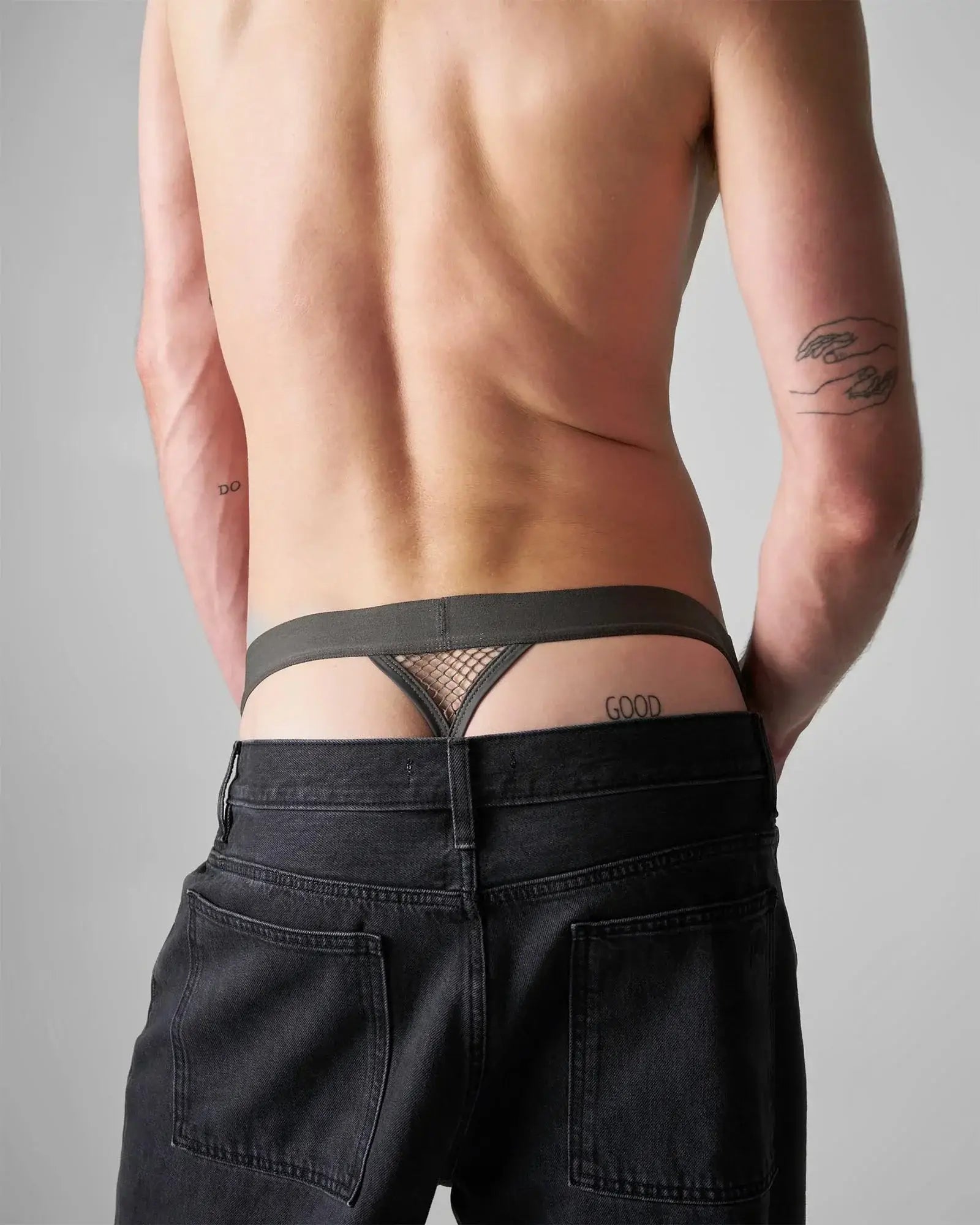 Edge net jock thong in black mesh with a solid waistband and good embroidered on the right side