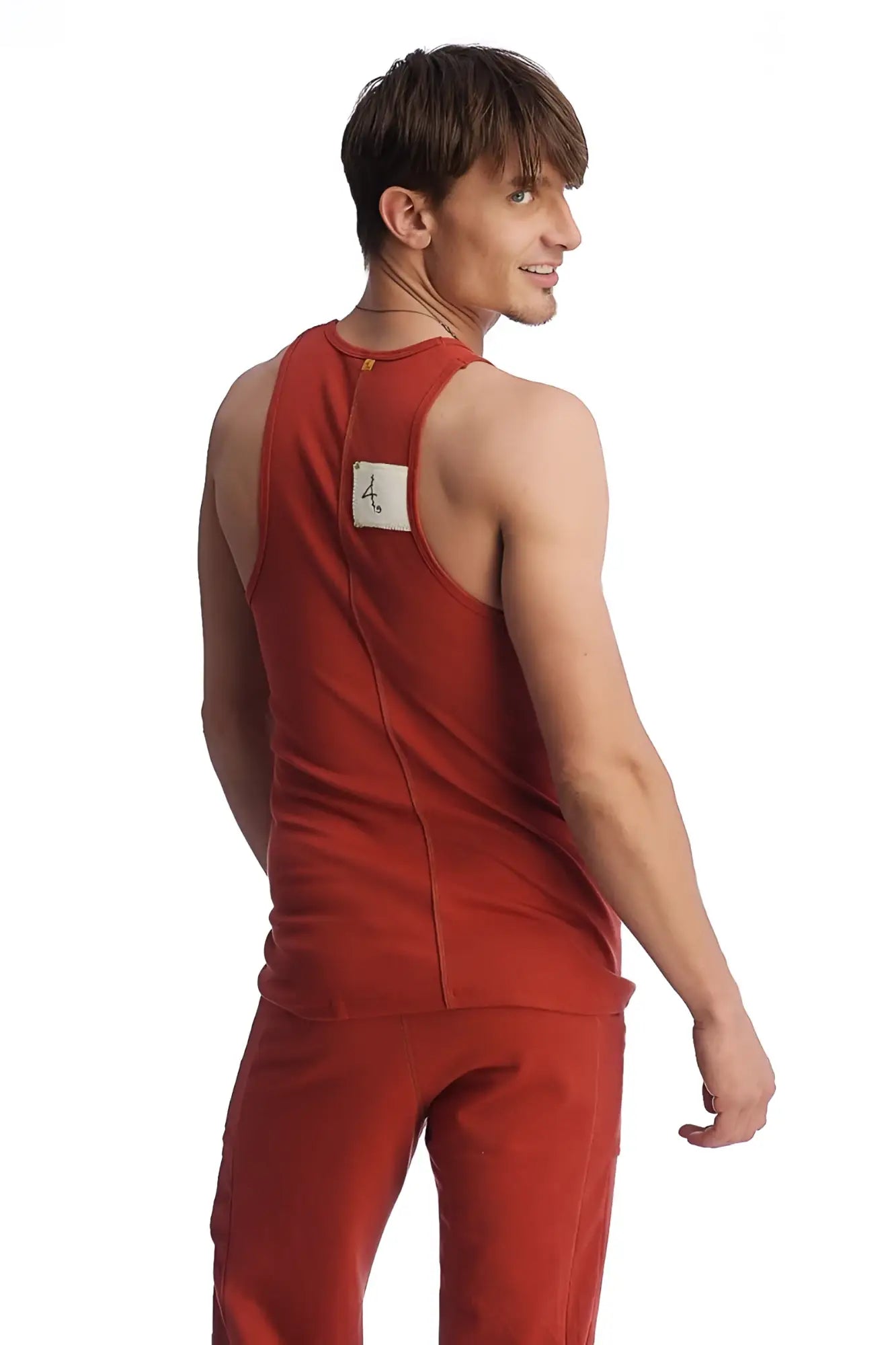 Back view of a red cinnabar edge sustain tank top with a white label featuring sleeveless lightweight fabric