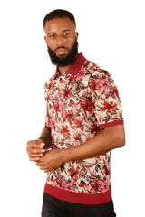 A man wearing an entwine form polo shirt with a red pink and brown floral pattern on beige with maroon accents