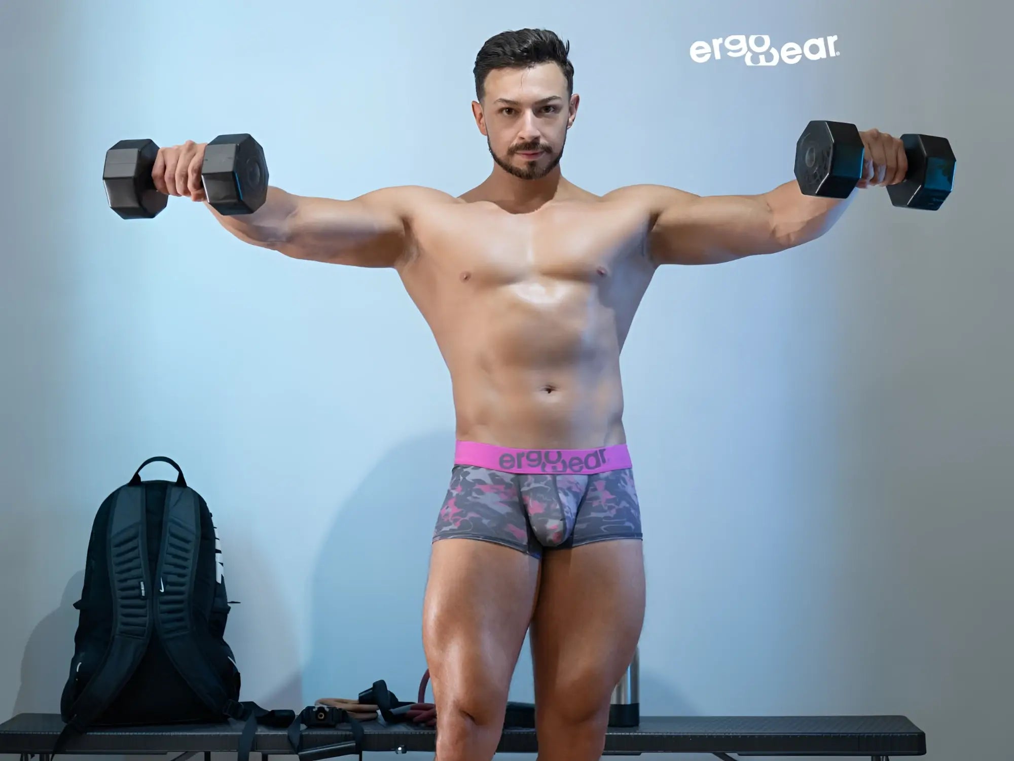 Black hexagonal dumbbells paired with pink camo ergoWear ew1716 max se trunks for workout use
