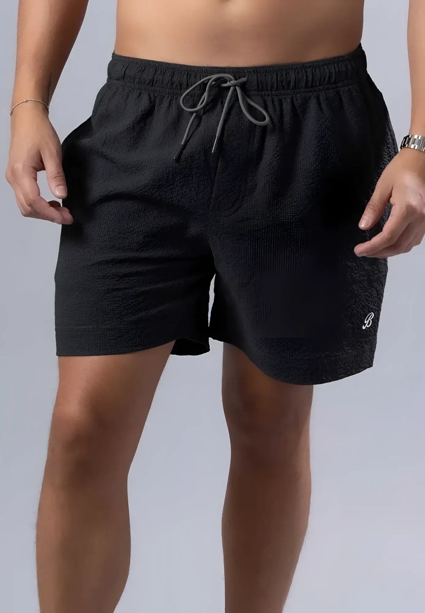 Black textured essential swim short with gray drawstring waistband and small white logo on lower right leg available in 3 colors