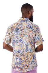 A man wearing an exclusive buzz s/s shirt with blue gold and cream paisley pattern on a light background