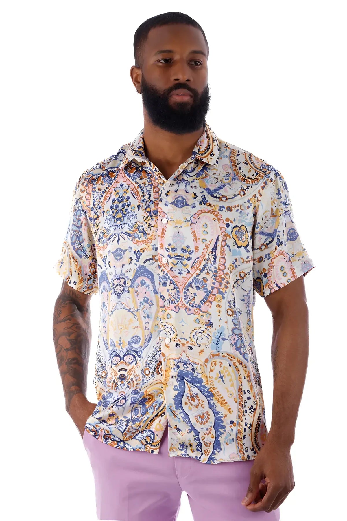 A man wearing an exclusive buzz s/s shirt with a blue orange and cream paisley pattern on a light background