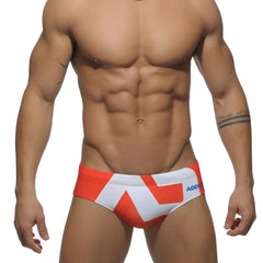 Extra-large logo brief swim trunks with orange and white geometric pattern and blue add branding on the side