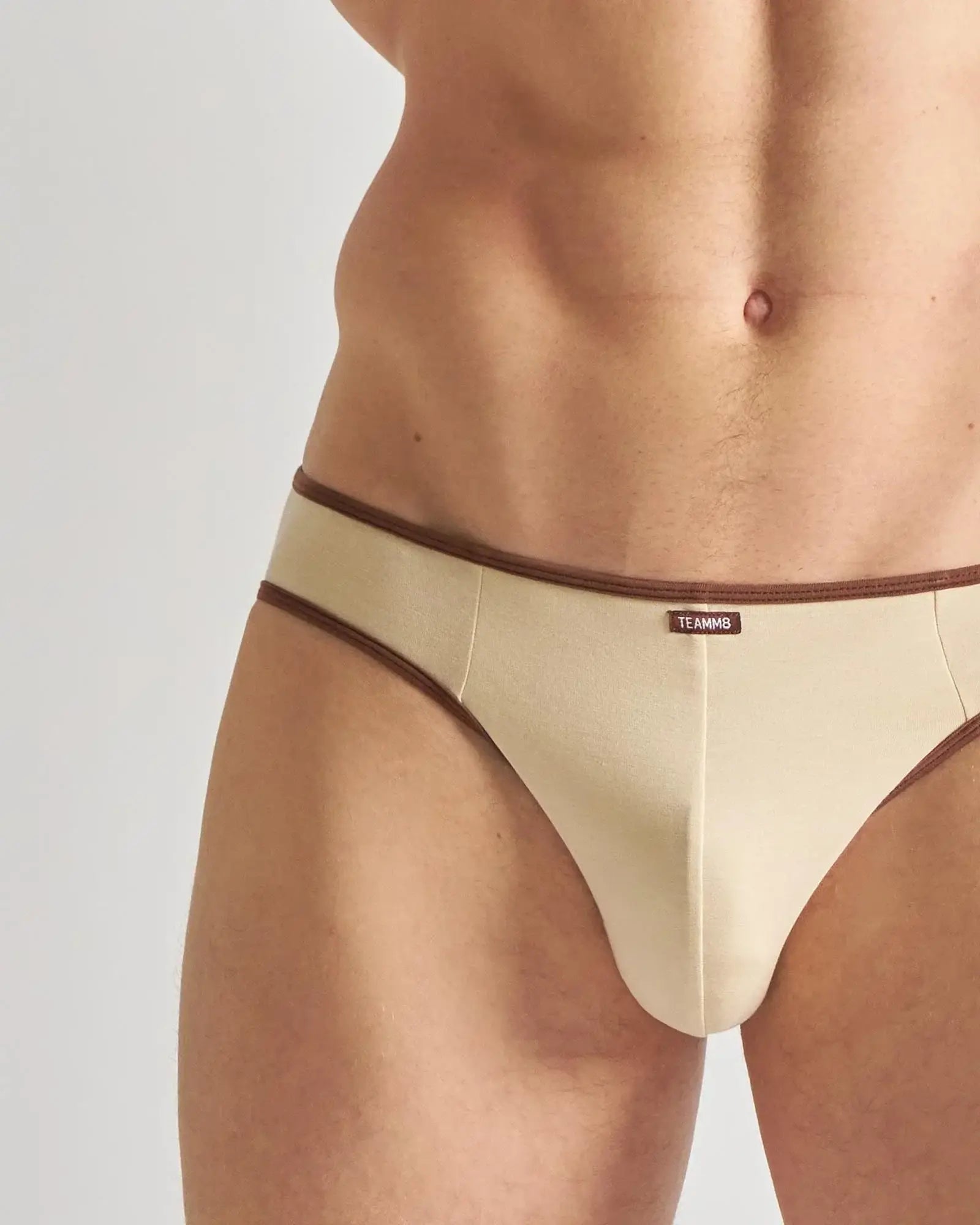 Beige teammg jockstrap briefs with brown trim designed for comfortable and stylish flaunting use