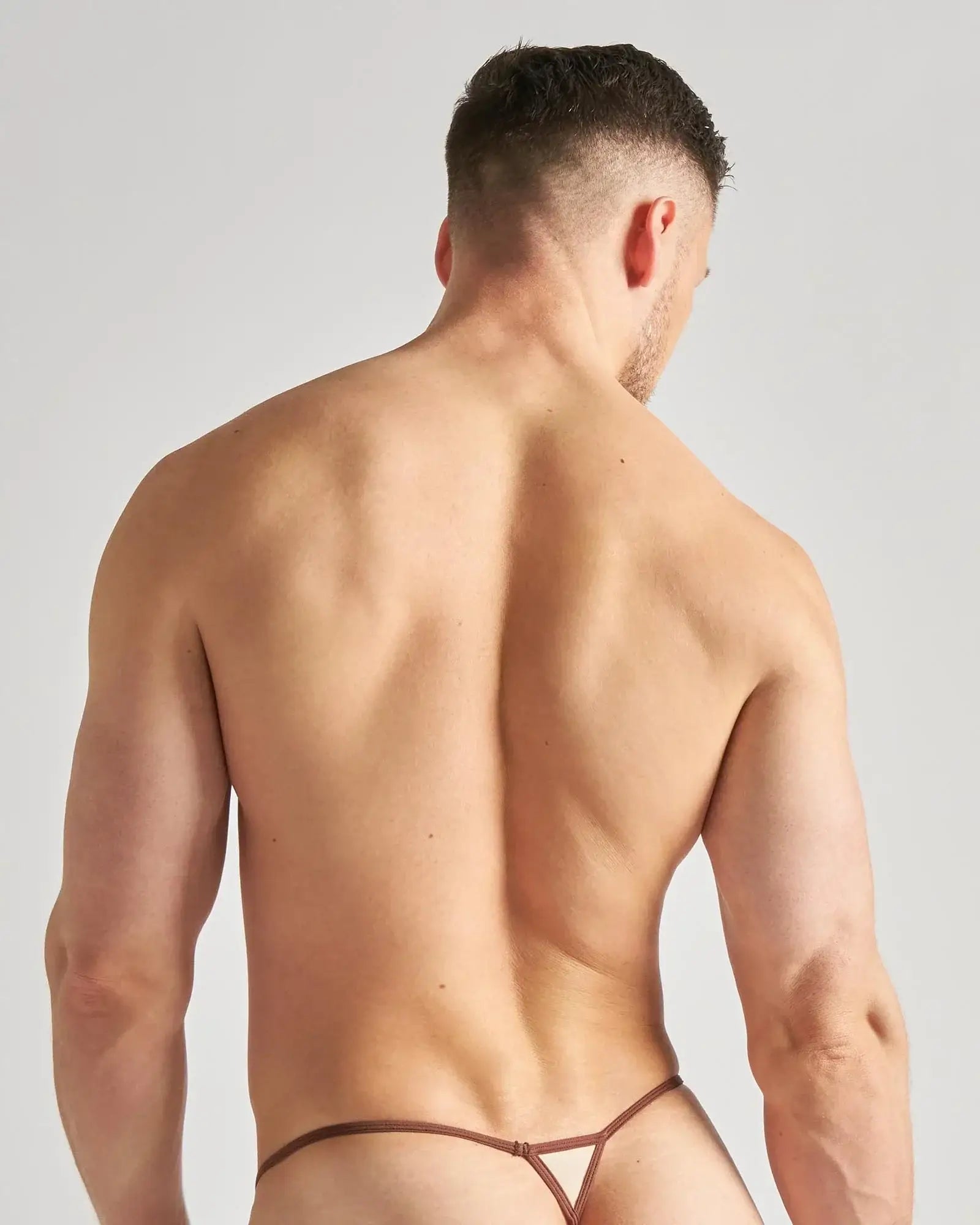 Brown flaunt micro thong with thin straps and triangular cutout design in a minimal lingerie style