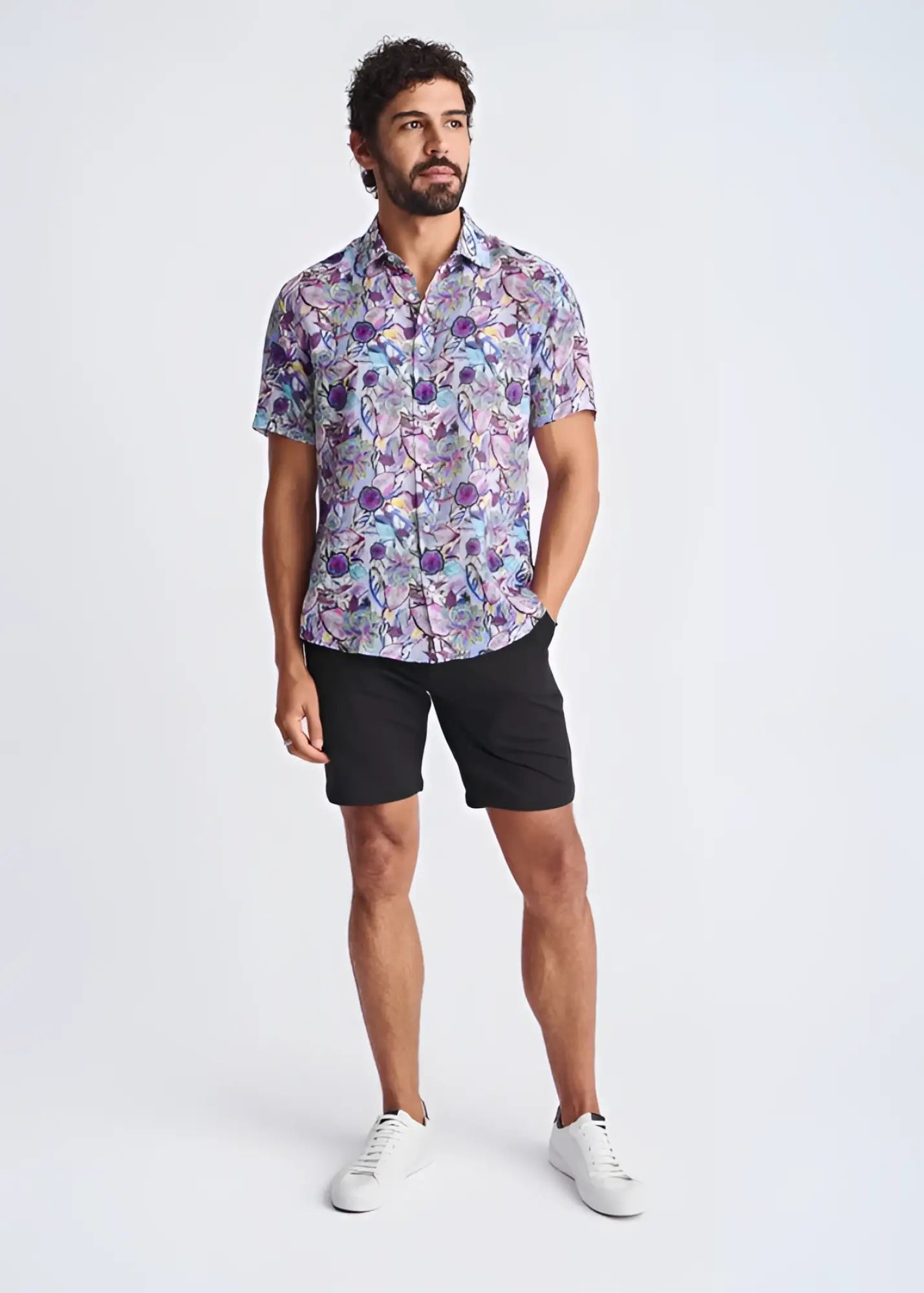 A man wearing a floral lightweight linen Tencel short-sleeved shirt in purple blue and pink