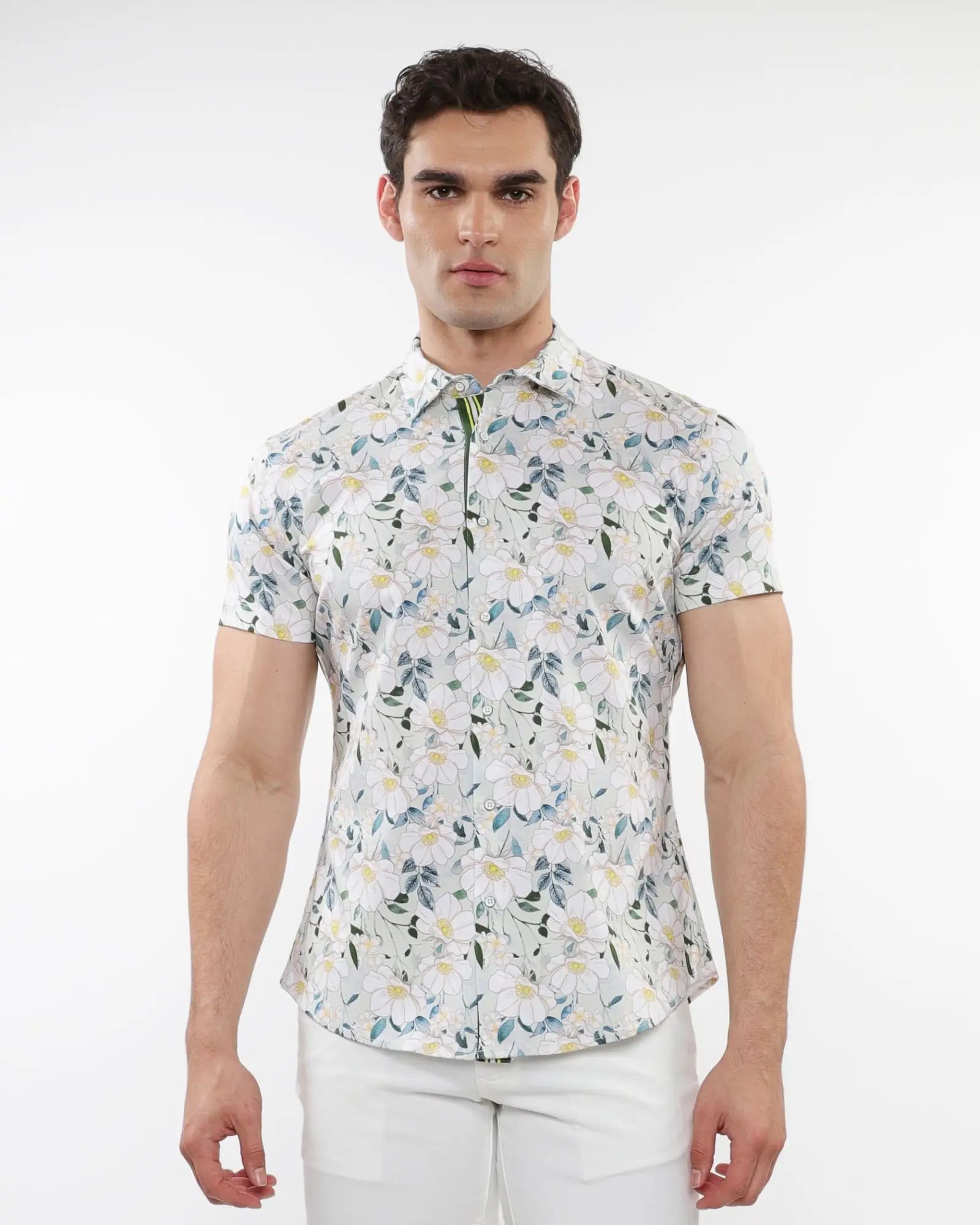 A man wearing a white floral print stretch knit short sleeve shirt with green and yellow delicate patterns