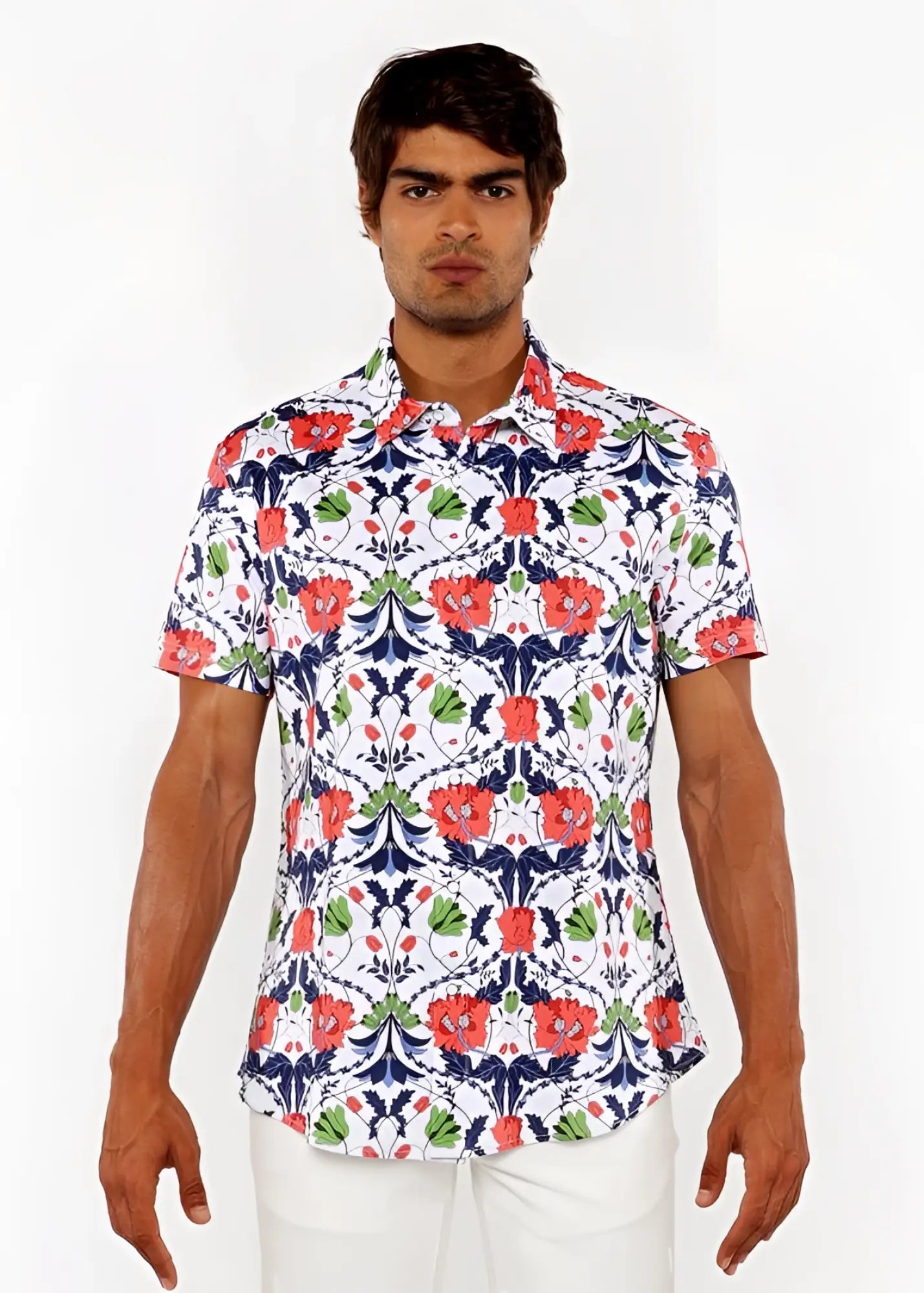 A man wearing a floral print stretch knit shirt with red poppies green leaves and navy blue vines on a white background