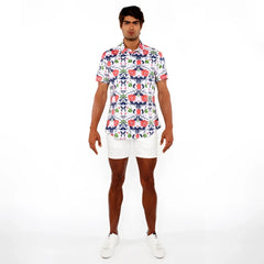 A man wearing a floral print stretch knit short-sleeved button-up shirt in red blue and green on white background