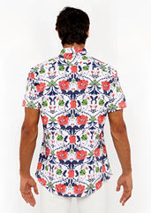 A man wearing a white short-sleeved floral print stretch knit shirt with red poppies and green leaves on navy vines