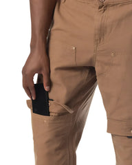 Tan forge pant cargo pants with multiple pockets and button closures designed for durable outdoor use