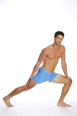 A man wearing light blue fusion yoga shorts made from breathable fabric for athletic use