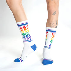 White crew socks with rainbow gay text and blue toe heel and cuff accents for pride and casual wear