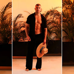 A woven straw hat with a dark blue band paired with gigo chalis black pants for a stylish summer look