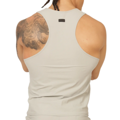 A sleek off-white racerback tank top with minimalist design and small black gigo club brand tag at the neckline