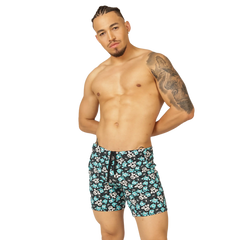 Menâ€™s swim trunks with black base teal and white skull patterns and matching drawstring waistband from Gigo Comics Beachwear