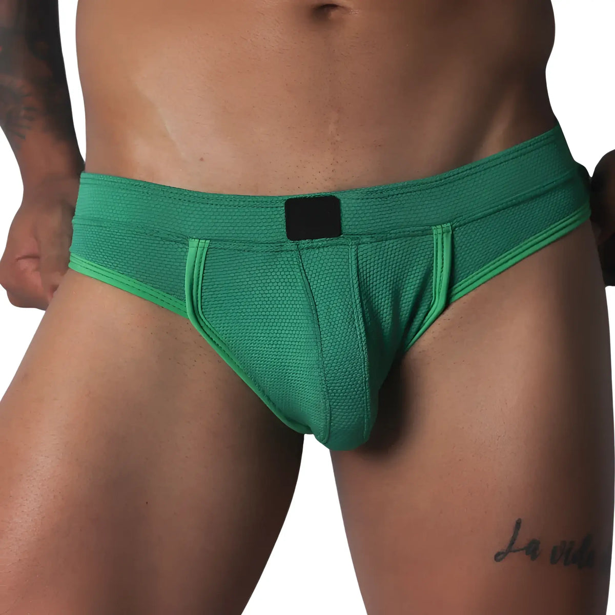 Green jockstrap featuring a textured honeycomb fabric, wide waistband, and a solid black central logo patch.