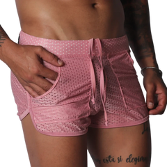 Pink, mesh athletic shorts with a drawstring waistband, side pockets, and curved hem detail.