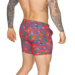 Gigo Macaws red beachwear swim trunks with vibrant blue green purple tropical leaves and toucan print