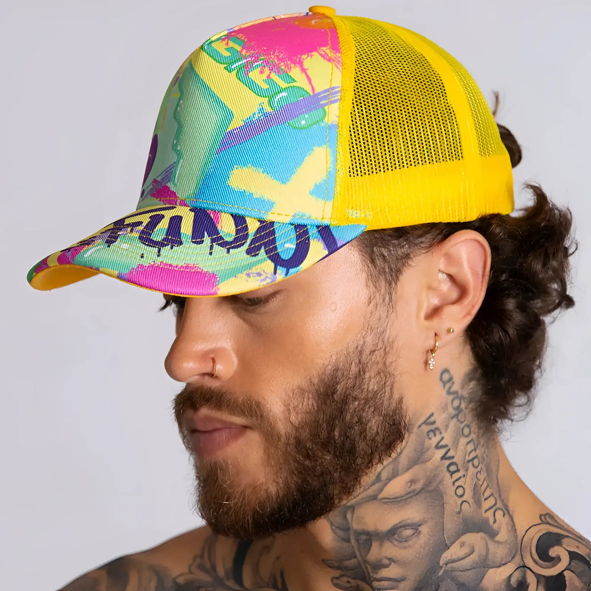 Vibrant graffiti-style gigo neon yellow caps trucker hat with yellow mesh back and bold pink blue green purple paint splatter