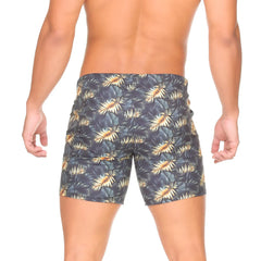 Dark blue gigo palms beachwear swim trunks with vibrant gold and green tropical leaf pattern for beach use