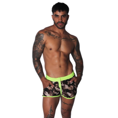 Men’s short camouflage print swim trunks with a bright neon yellow elastic waistband, trim, and front drawstring.