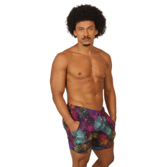Menâ€™s galaxy-print swim trunks in purple teal and pink cosmic nebula design from Gigo Universe Beachwear
