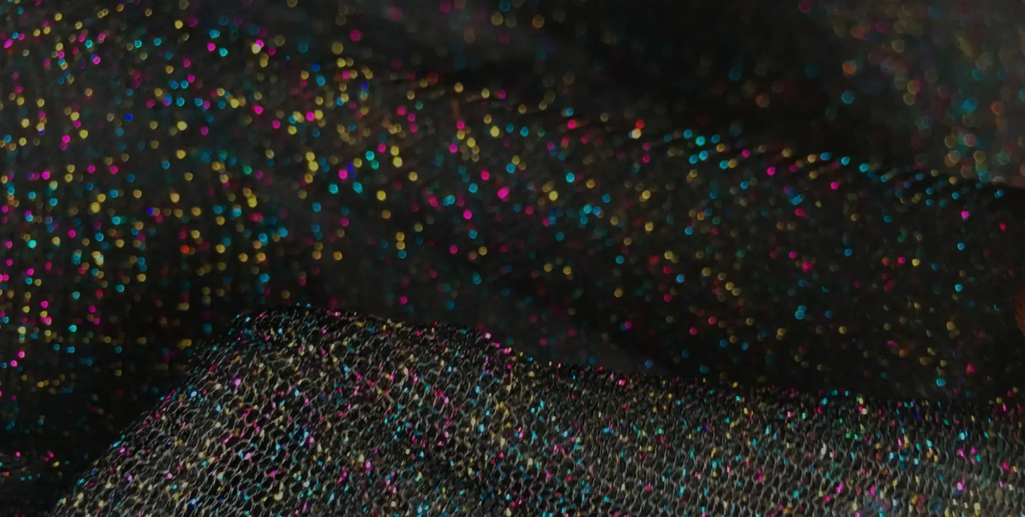 Black mesh tee featuring sparkling multicolored glitter fabric for a stylish and festive look