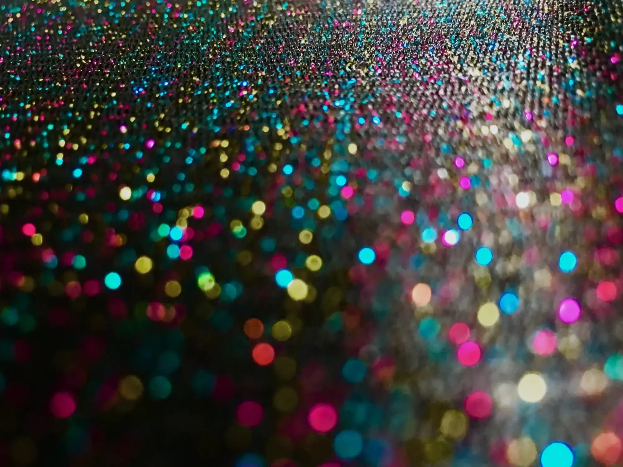 Glitter mesh tee featuring a vibrant multicolored glitter surface with pink blue gold and teal shimmering particles