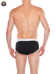 Back view of a man wearing black brief underwear with white waistband and gray trim by AMERICAN JOCK