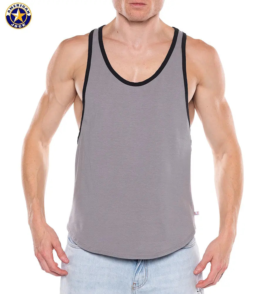 Man wearing a gray tank top with black trim and scoop neckline paired with light blue jeans by American Jock