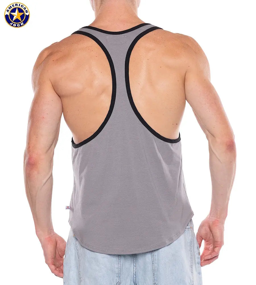Back view of a man wearing a gray racerback tank top with black trim paired with light blue denim shorts by AMERICAN JOCK