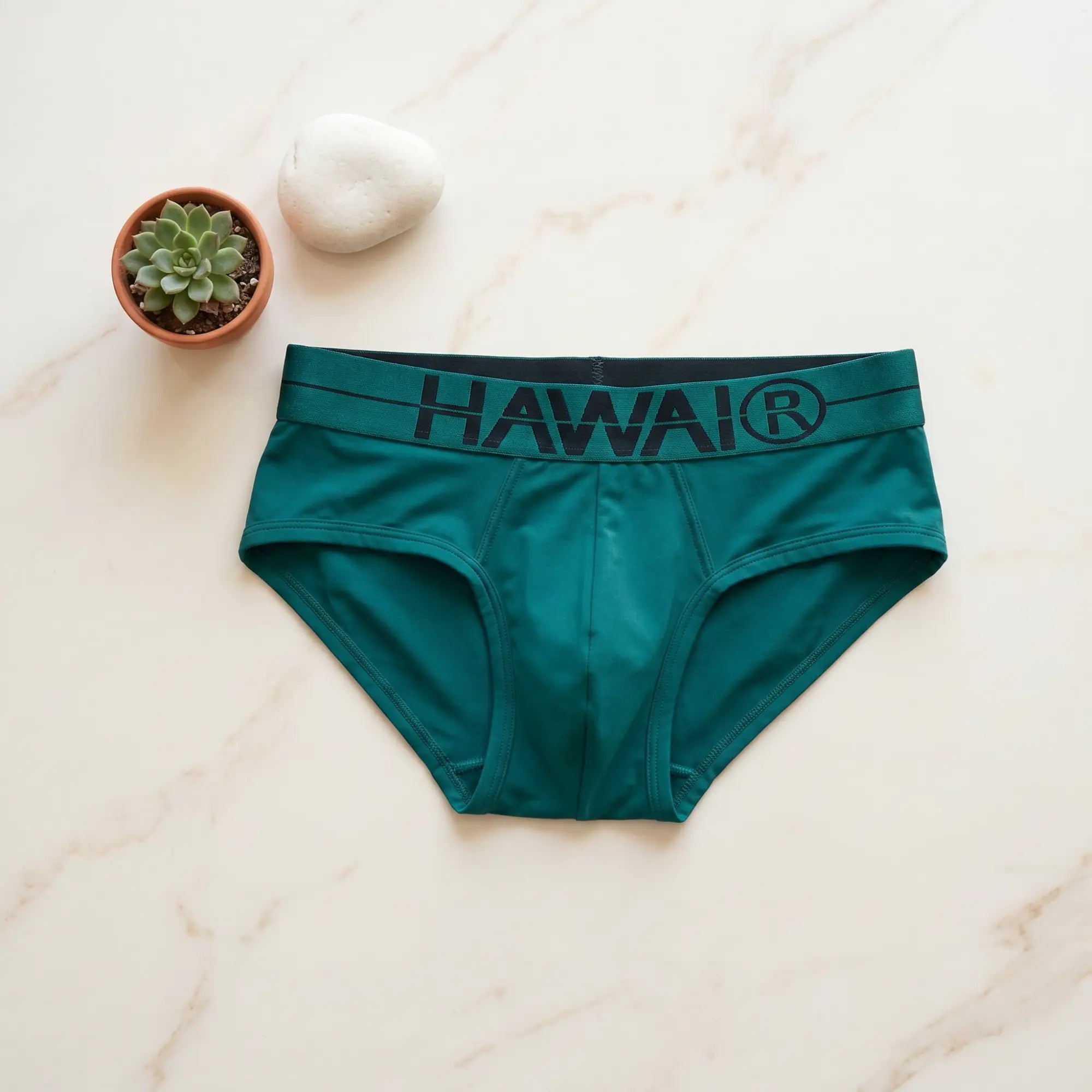 HAWAI® teal green microfiber men's briefs flat lay on marble surface with branded registered trademark waistband