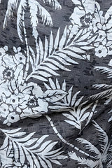 Hawaiian print swim short in black fabric with white tropical palm tree and flower pattern