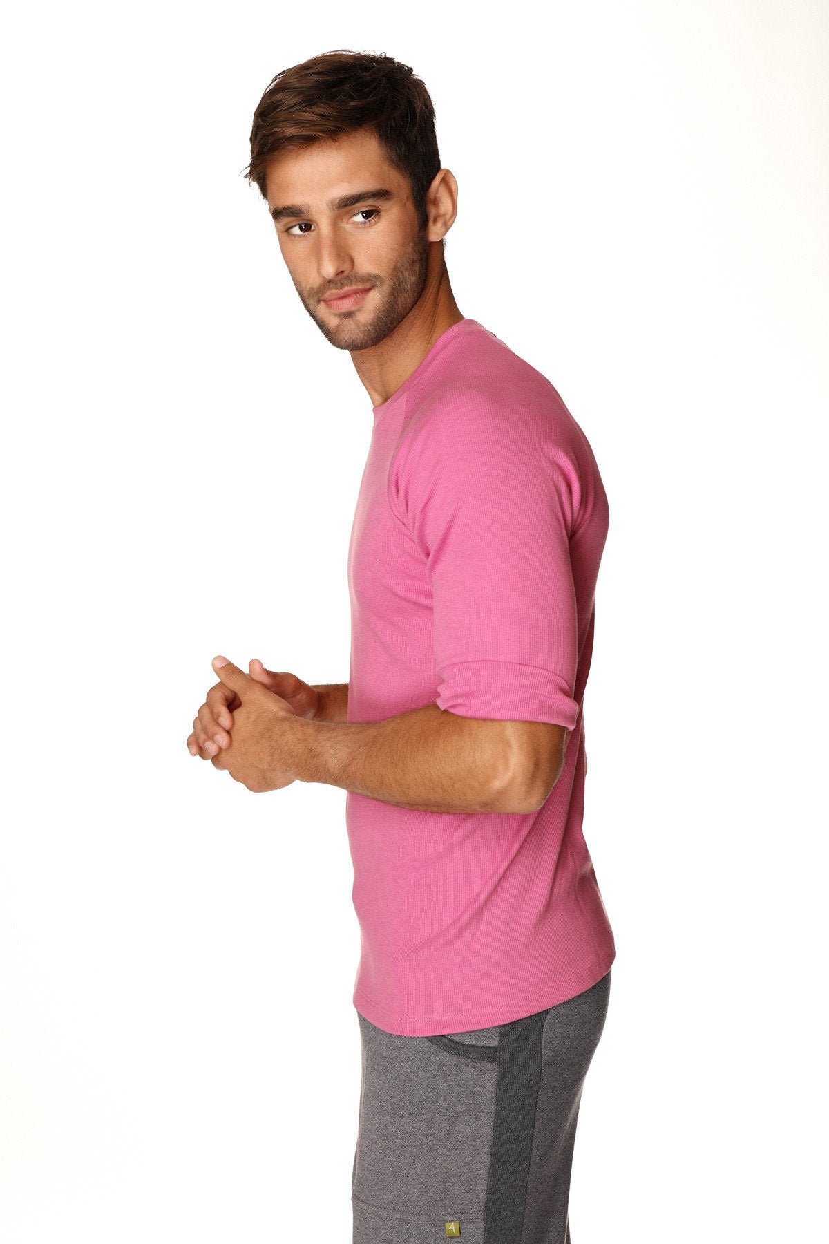 A man wearing a vibrant berry hybrid crew neck raglan tee with short sleeves and rolled cuffs