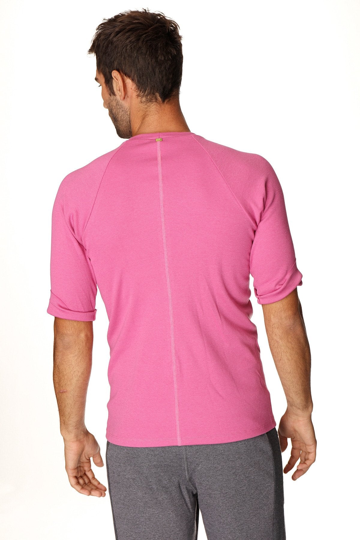 A vibrant berry pink hybrid crew neck raglan tee with textured fabric and short sleeves for athletic wear