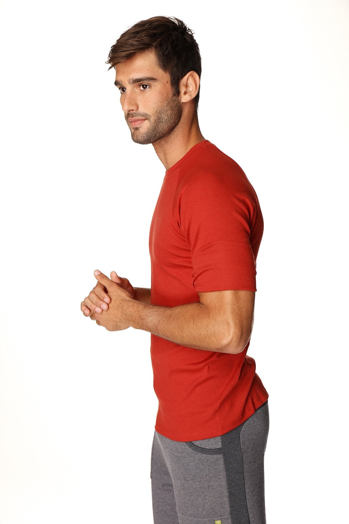 A man wearing a cinnabar red hybrid crew neck raglan tee with short sleeves designed for athletic use