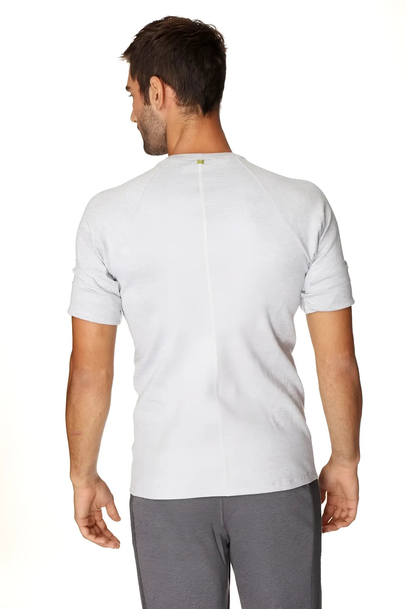 Back view of hybrid crew neck raglan tee in heather grey with subtle vertical seam and small green logo at neckline