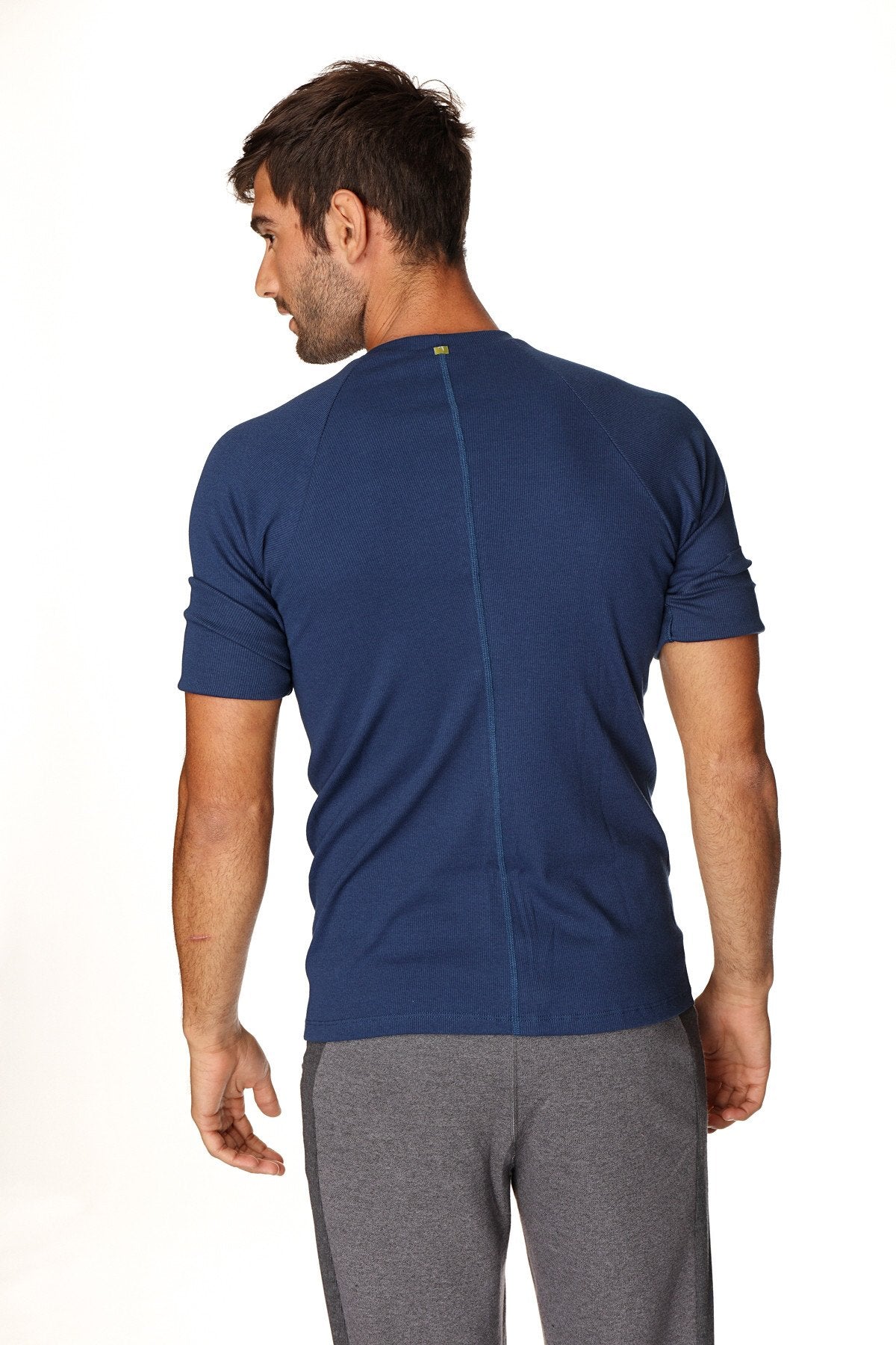 Navy blue short-sleeved athletic hybrid crew neck raglan tee shown from the back with a central seam for activewear use