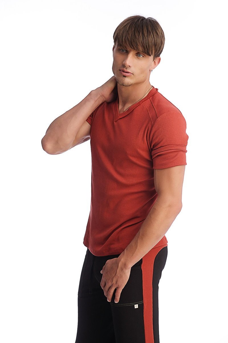 A man wearing a cinnabar red hybrid v-neck short-sleeved t-shirt with subtle seam detailing