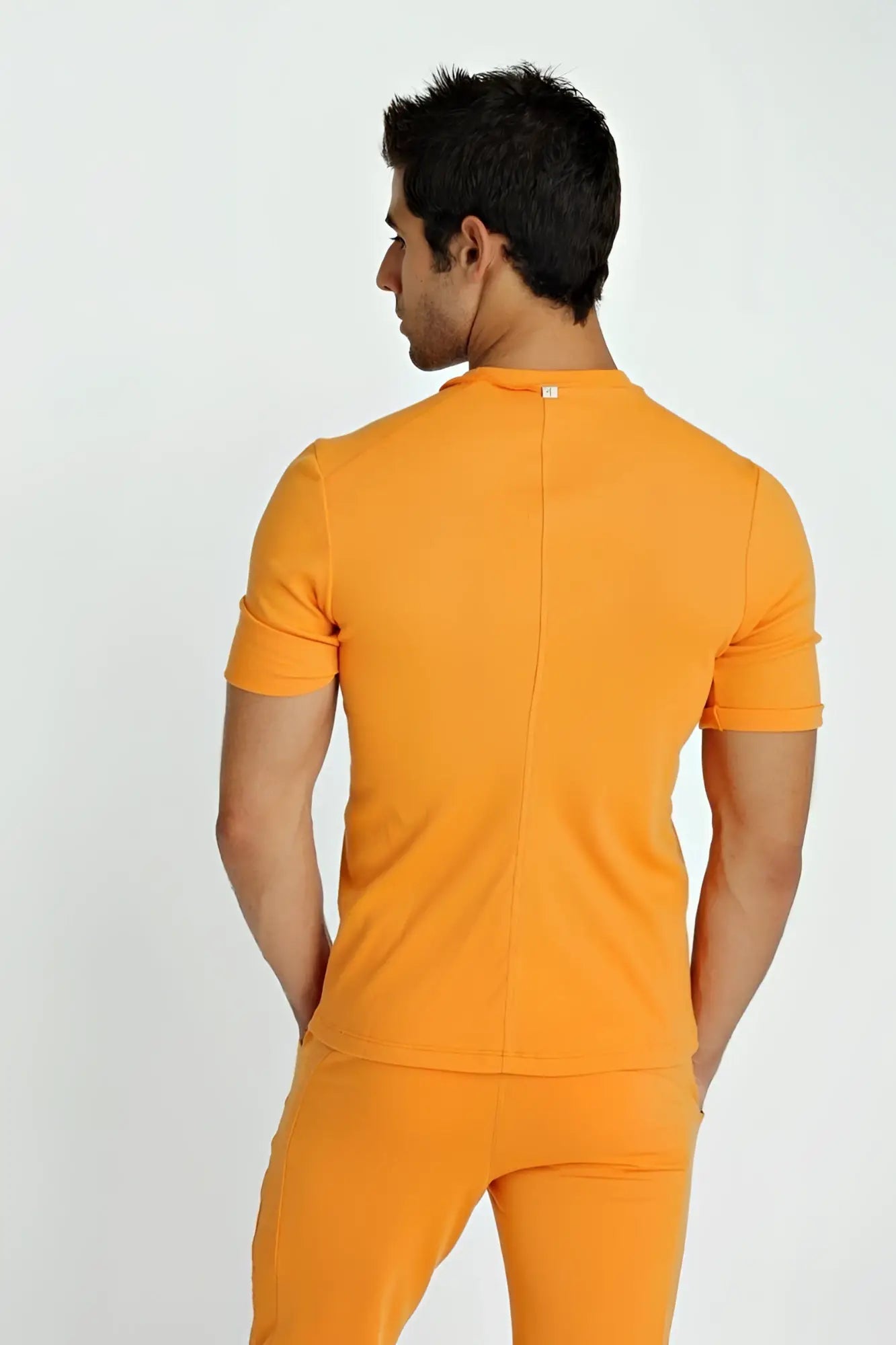 Orange short-sleeved fitted hybrid v-neck t-shirt with central back seam and subtle neckline brand tag shown from back