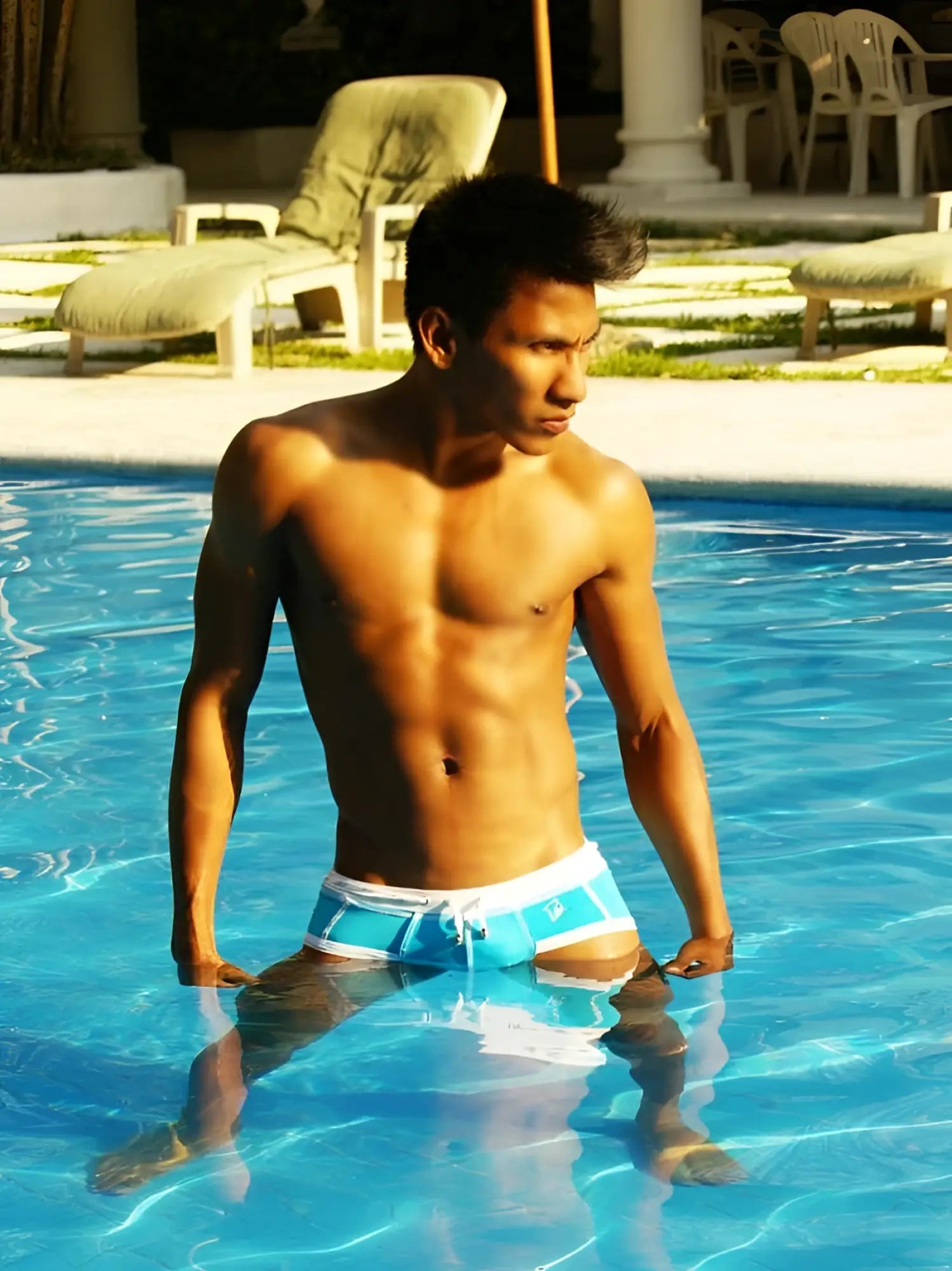 A man wearing icker sea cord contrast trim and stitching bikini swimwear in blue and white standing in a pool