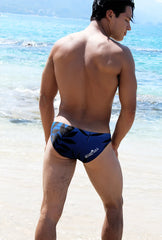 Back view of icker sea floral bikini swimwear navy blue blue swim trunks with black leaf patterns and white logo