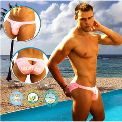 Back view of pink icker sea kiss my ass back cut out slip bikini swimwear men’s swim trunks with cheeky graphic
