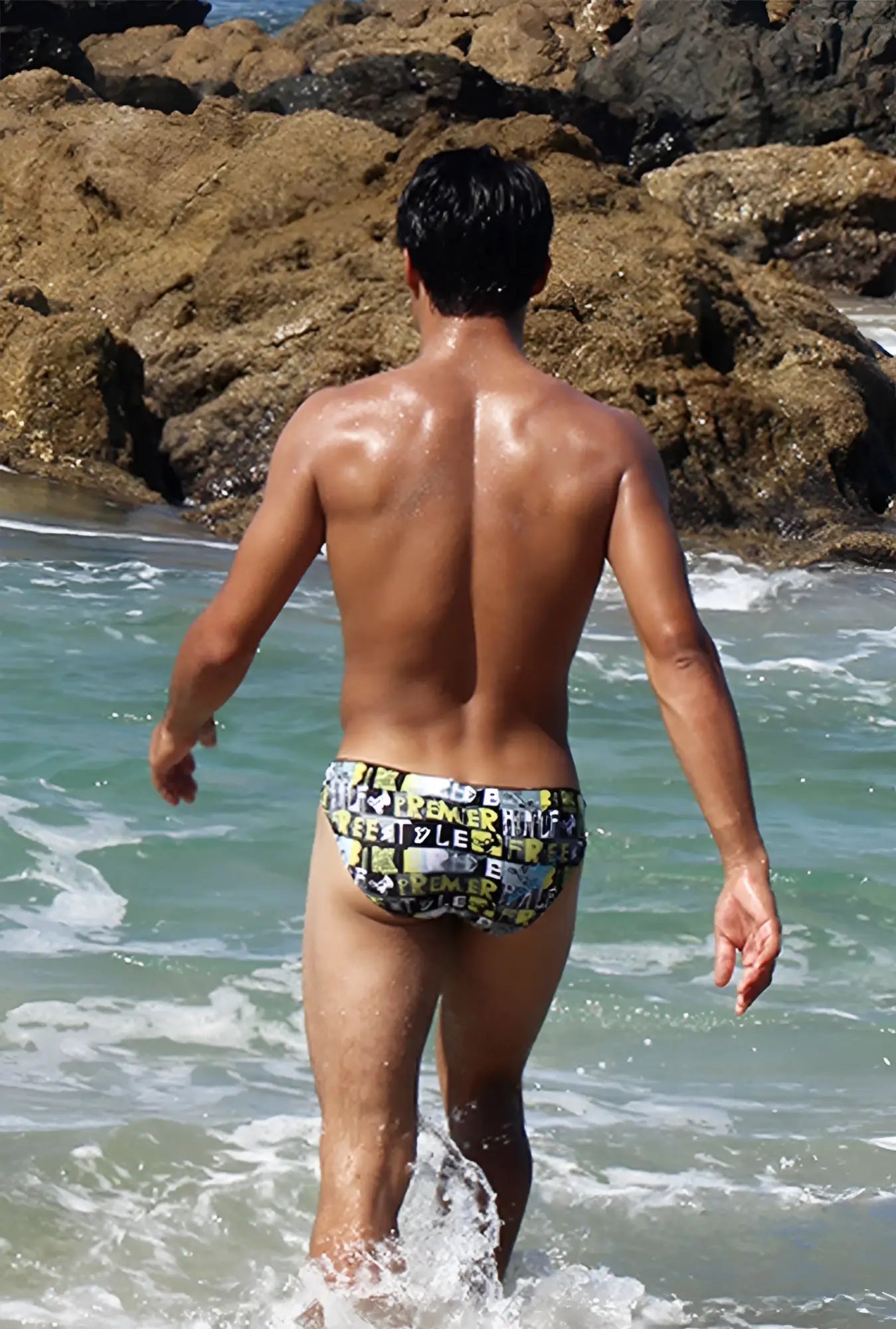 Icker Sea letters bikini swimwear swim trunks with bold black and yellow graphic design on a dark background